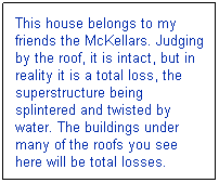 Text Box: This house belongs to my friends the McKellars. Judging by the roof, it is intact, but in reality it is a total loss, the superstructure being splintered and twisted by water. The buildings under many of the roofs you see here will be total losses.
